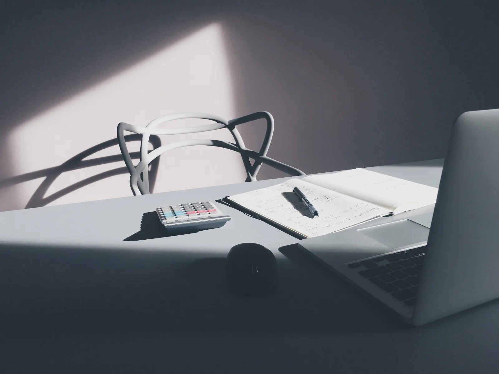 Escritorio con laptop y calculadora, para estimar la cuota de un préstamo personal